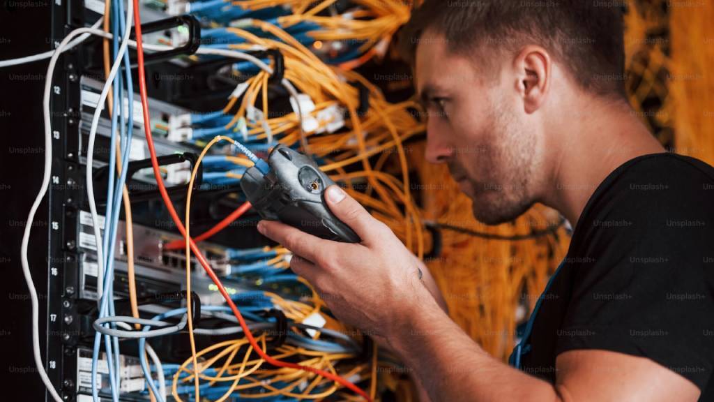 man looking at server connection in server room