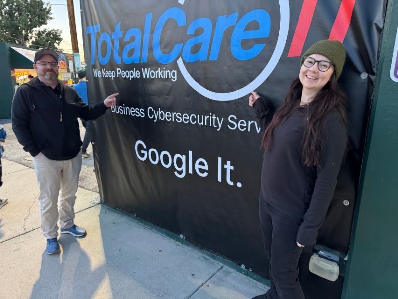 Aaron and Chelsea in front of signage at the Hawks Baseball Stadium