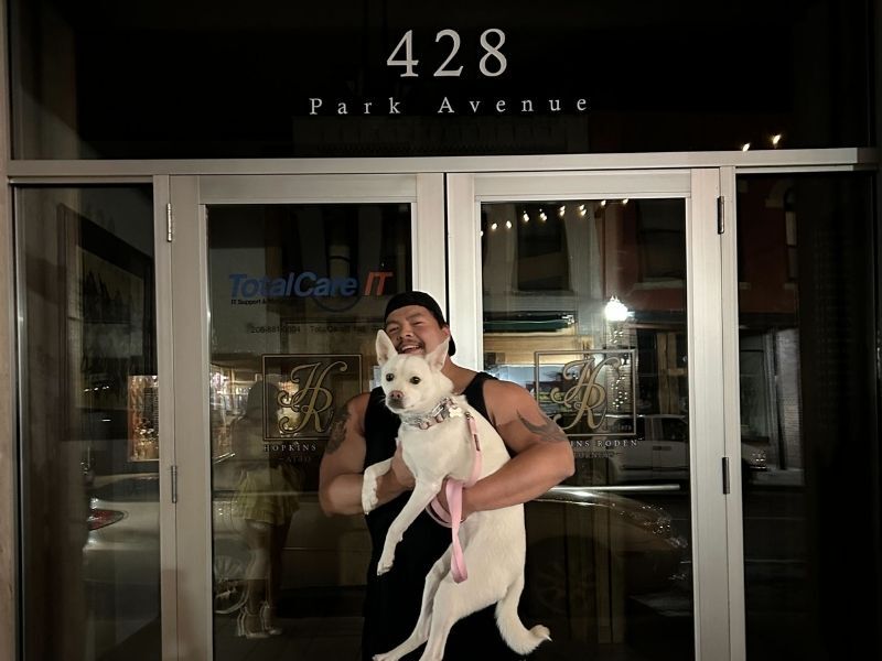 Santiago with his dog in front of office at night
