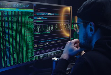 man looking at computer screen at data